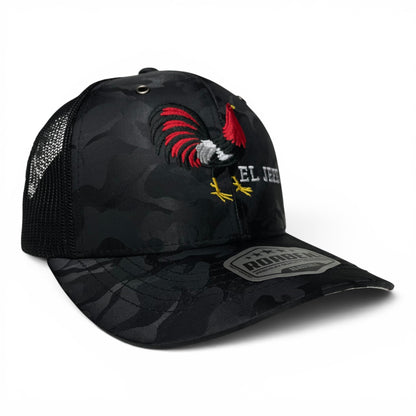 ROABEN camouflage trucker hat featuring an El Jefe rooster design, Mexico flag under visor, structured front panels, and adjustable snapback closure.